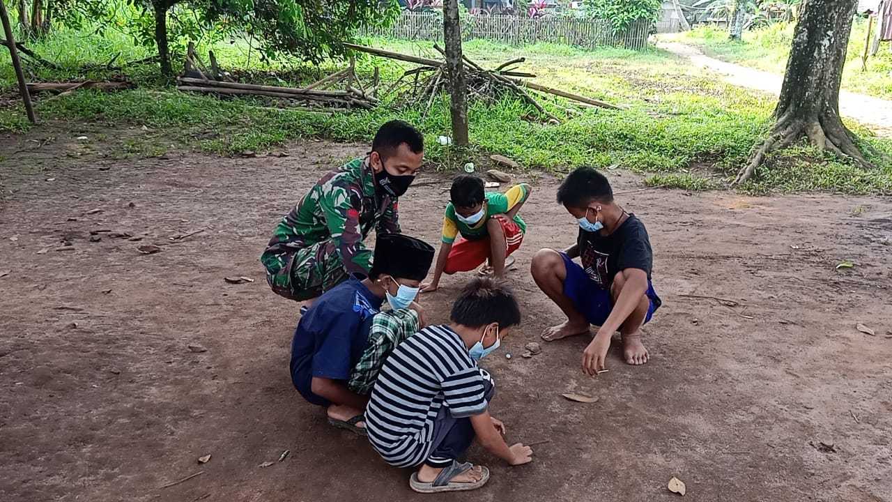 Ingat Masa Kecil, Pratu Yulian Ferbry Asik Main Kelereng Bersama Anak-Anak Desa Jambe