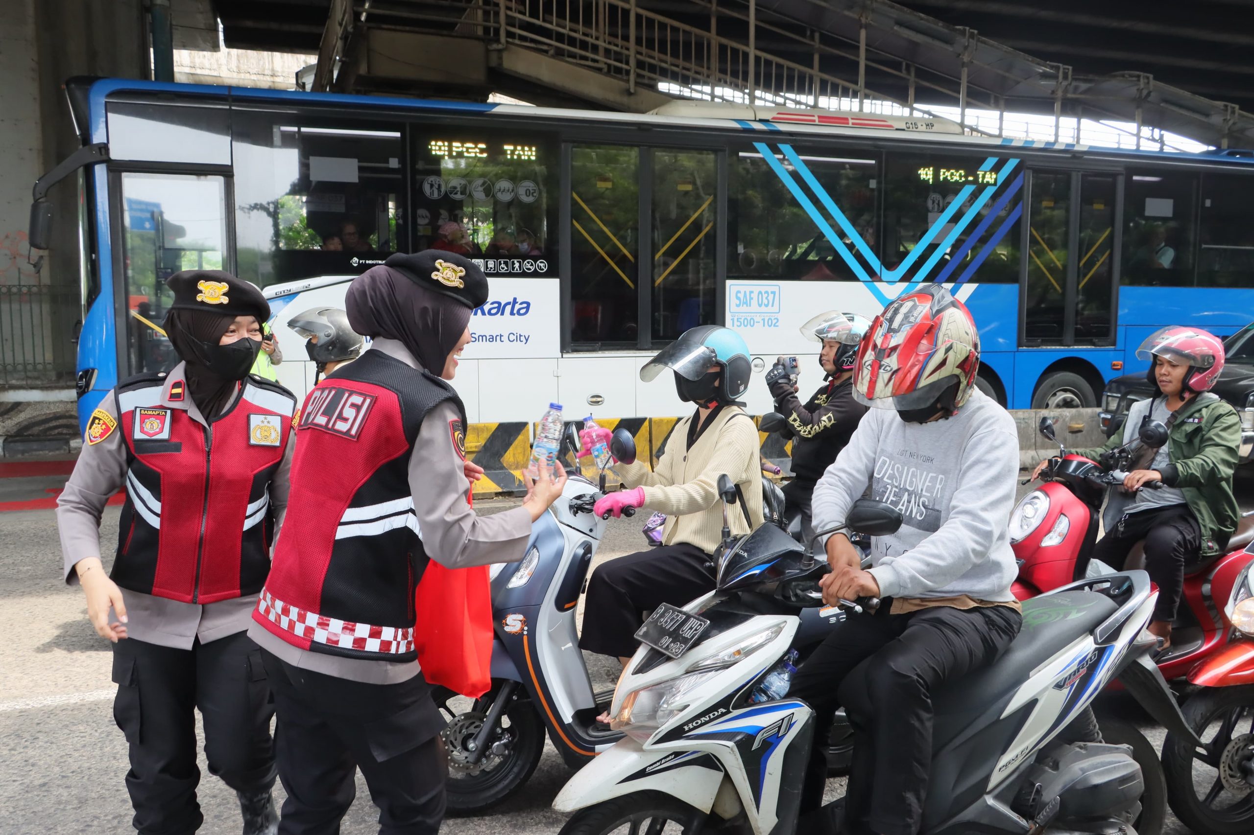 Polwan Polres Metro Jakut Bagikan Permen dan Air Mineral dalam Peringatan Hari Buruh Sedunia